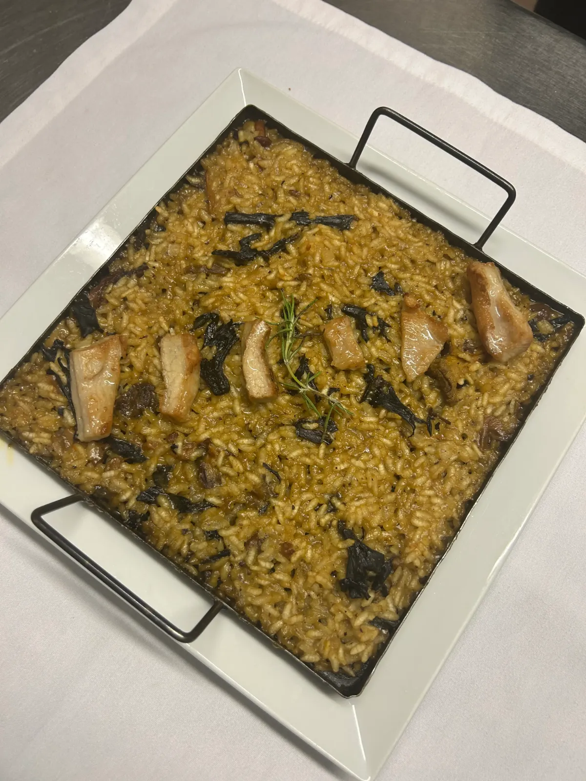 Seasonal rice with mushrooms and meat in a paella pan, from the La Estrella 1924 menu