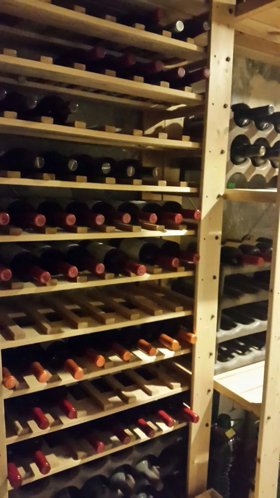 Prestatgeria de fusta plena de vins de cellers petits