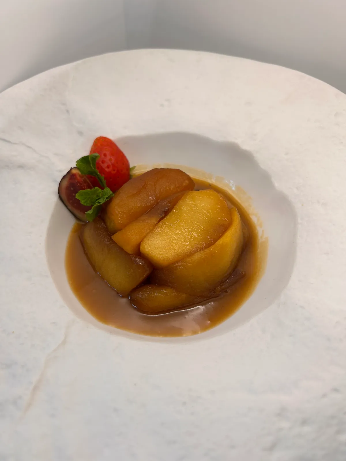 Homemade baked apple dessert with its juices and red berries