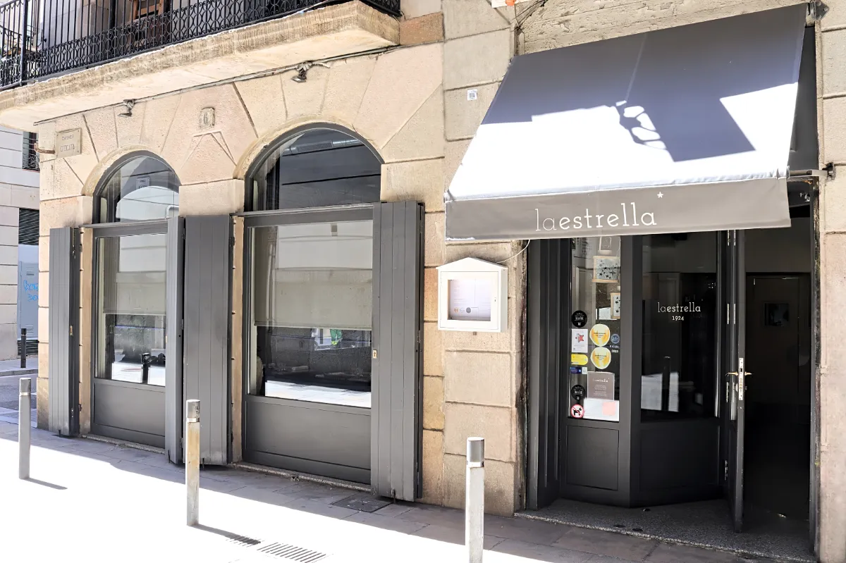 Front of La Estrella 1924 restaurant with its grey awning at Carrer d'Ocata 6, El Born, Barcelona